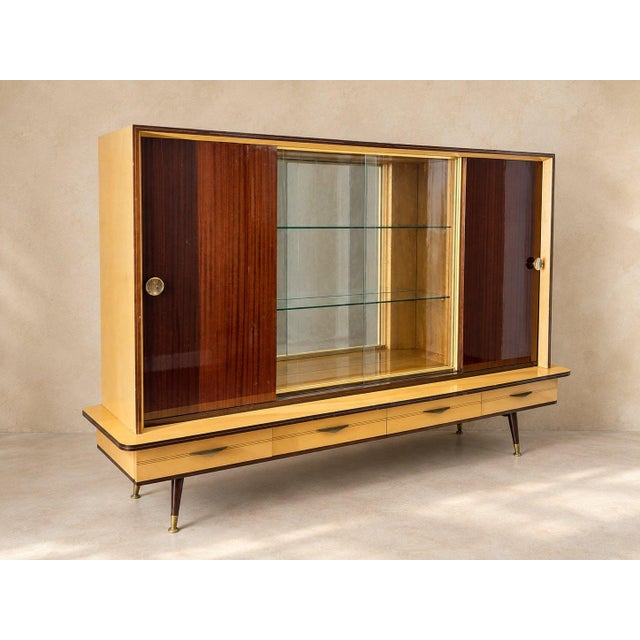 Half furniture, half stage set. Deep, glossy reddish brown doors slide to either side of a glass center with two glass...