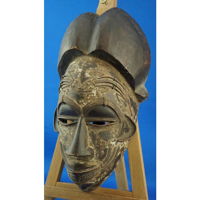 Item description: African tribal mask made of wood, presumably Wengé wood, entirely hand-carved with numerous copper...