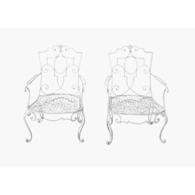 A direct attribution to Raymond Subes, this stunning pair of iron chairs beautifully highlights his intricate scroll work....