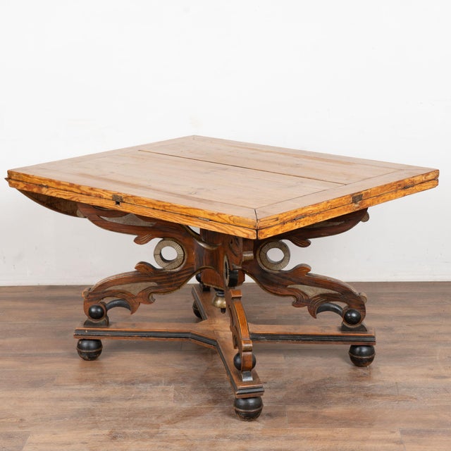 19th century Swedish drop leaf table, crafted in pine. The table features a dramatic carved pedestal base with four legs,...