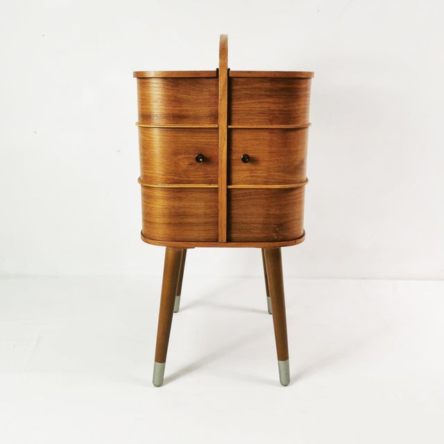 Mid-Century Modern Danish teak sewing box (1960s). Crafted from wood featuring a beautiful teak veneer with rich graining,...