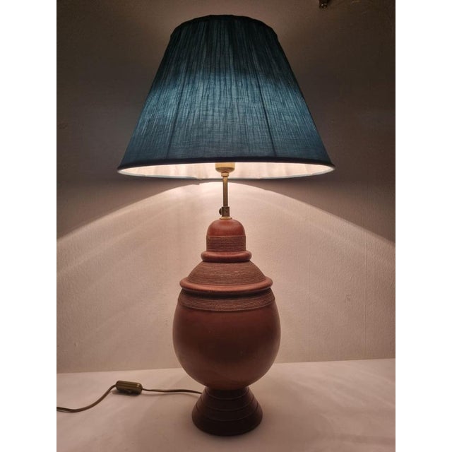 Table lamp with carved wooden body and elegant turquoise lampshade, from the 1960s-70s. Thanks to its clean design, it can...