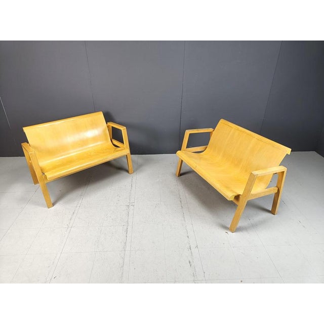 This pair of mid century benches are made out of plywood curved seats and a wooden base. The design is much like the Alvar...