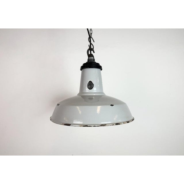 Industrial grey enamel factory pendant light made in United Kingdom during the 1960s. White enamel inside the shade....