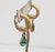 19980s goldtone textured hoop rams heads with tear drop shaped faux-aquamarine drop clip earrings Marked "TRIFARI TM" on...