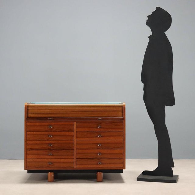 Solid wood centerpiece with glass top, drawers, and a rolling shutter, crafted with walnut veneer. In very good condition,...
