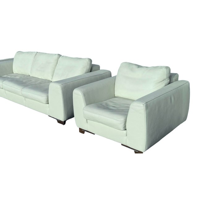 Experience timeless elegance with our Roche Bobois white leather club chairs and sofa set, circa early 2000. This...