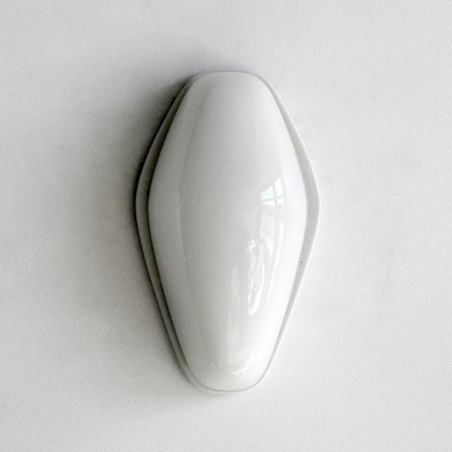 Elegant pair of Wagenfeld wall lights designed by Wilhelm Wagenfeld for Lindner, in ivory porcelain with opaque glass bulb...