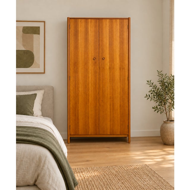 A stylish 1960s teak wardrobe with two doors, rounded frame detailing and tapered legs. Internally fitted with a hanging...