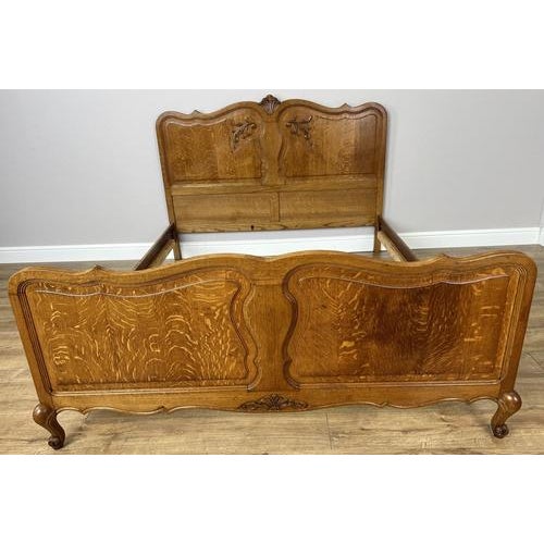 A beautifully crafted Vintage French Louis double bed frame , showcasing elegant curves and rich oak grain throughout....