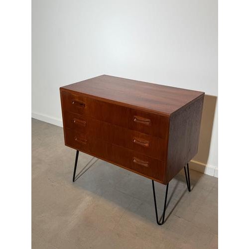 A stylish mid-century modern chest of drawers by G-Plan, crafted in richly figured teak and elevated on elegant black...