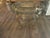 An elegant round occasional table featuring an antiqued gold-tone metal base and a clear beveled-glass top. Open...
