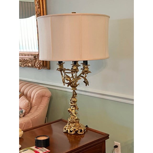 Mid Century Pair of lamps. Gilded gold candelabra figural with shade. A Louis XV Style Gilt Bronze Four Light Candelabrum...