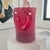 A sculptural hand-blown art glass vase rendered in saturated ruby red, featuring a series of evenly spaced pinched dimples...
