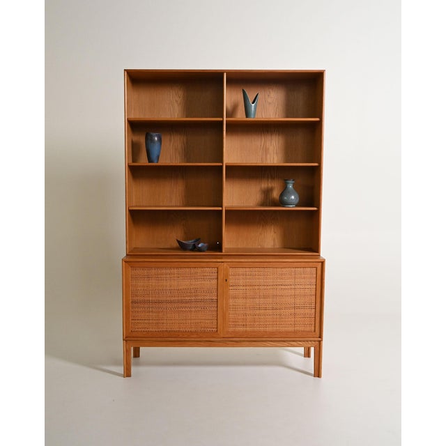 Oak bookcase with adjustable shelves and a storage compartment with rattan doors. Designed by Alf Svensson for Bjästa...