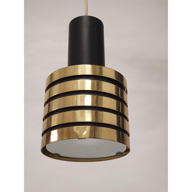 Paavo Tynell lamp model K2-49 for Taito Oy, black painted metal with brass rings and a glass diffuser. The lamp is in...