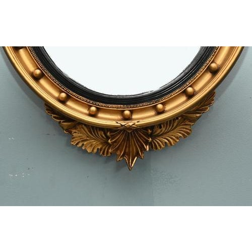 Regency style round mirror finely carved with a gilt finish Surmounted by the carved eagle at the top Glass is convex so...