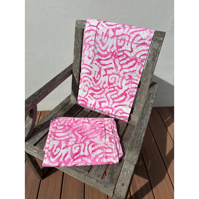 These are two separate pieces of cotton(?) fabric printed with an abstract batik design in shades of pink on a white...