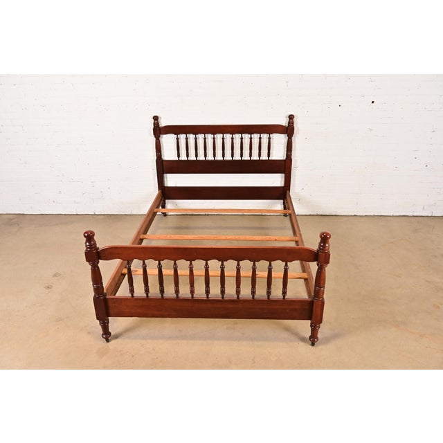 A beautiful American Colonial style carved solid mahogany full size spindle bed frame In the manner of Ethan Allen USA,...
