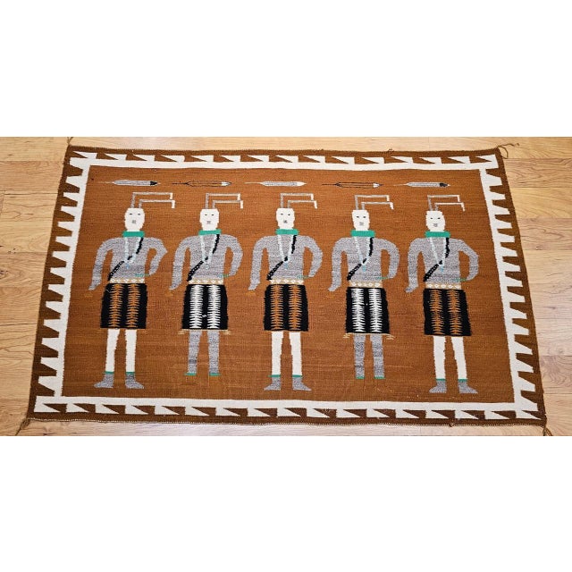 This vintage Native American Navajo Yei rug, woven in the mid-1900s, features a powerful and visually captivating design...
