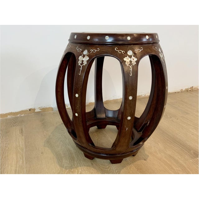 A stylish Chinese hardwood barrel-shaped stool with circular inset top, inlaid koi fish flowers and vines, pierced...