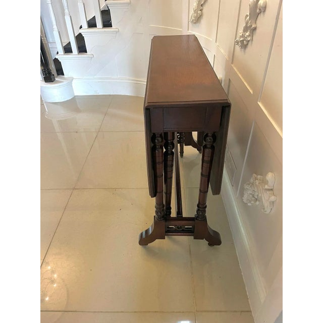 Antique Victorian quality solid walnut Sutherland table having a quality solid walnut top with two drop leaves and a...