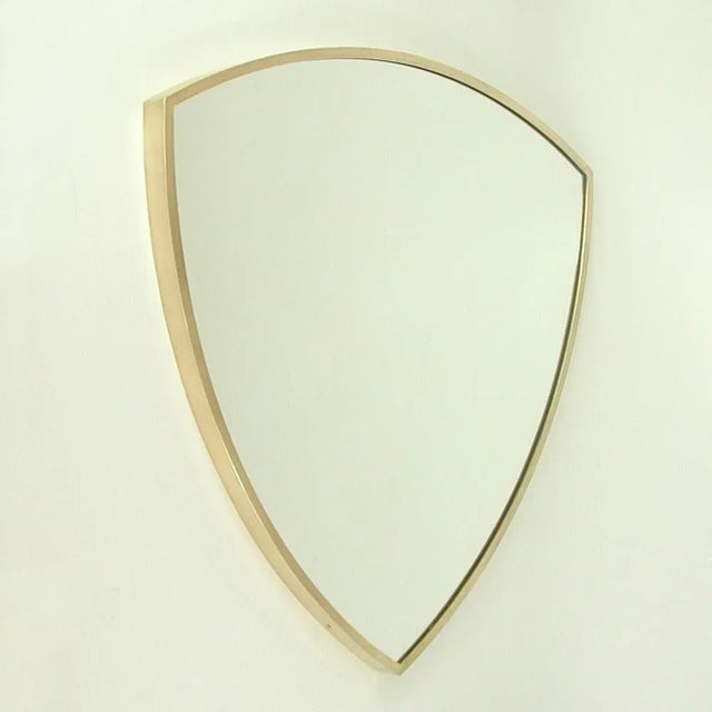 This minimalist shield shaped wall or fireplace mirror was designed and manufactured in Italy in the 1950s. It features a...