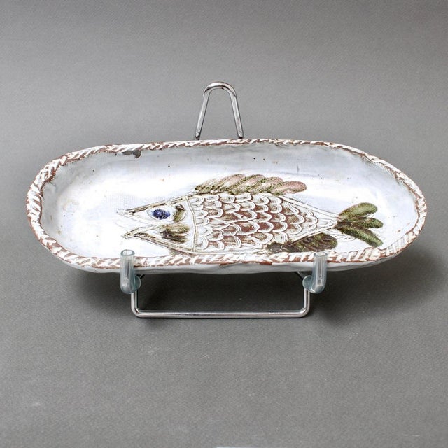 French ceramic decorative dish with fish motif (circa 1970s) by Albert Thiry. An oval-shaped ceramic dish has a chalk-...