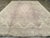 A vintage European Oushak large carpet. The light colors of this decorative Oushak belie the wild central cartouche...