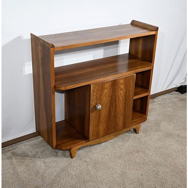 Small solid walnut furniture and walnut veneer, composed of shelves and a central door pulled by a large chrome button. On...