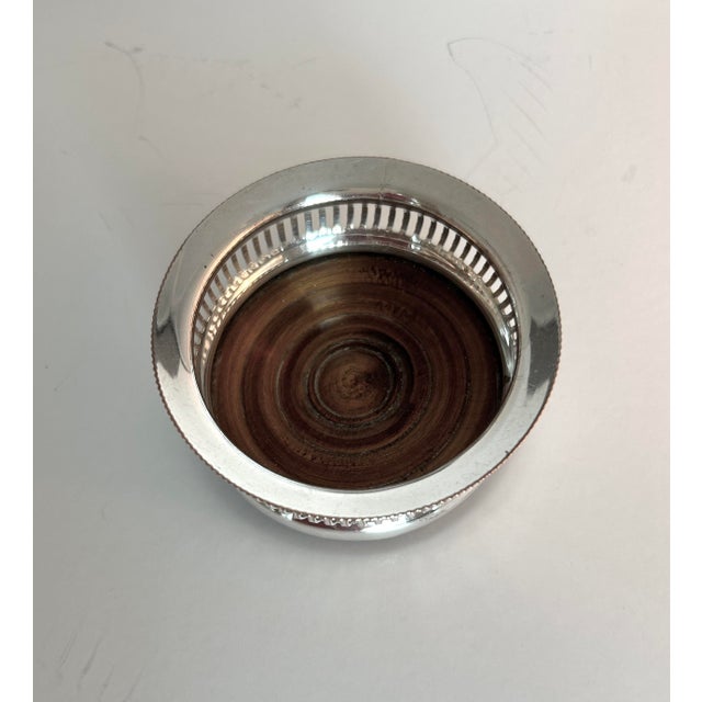 Elegant vintage Sheffield silver-plated bottle coaster with a beautifully pierced gallery, beaded rim, and turned hardwood...