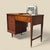 A Singer Slant-O-Matic 600 sewing machine housed in a streamlined mid-century wood cabinet. The machine folds beneath the...