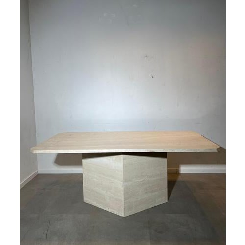 Elegant dining table crafted entirely from beautiful light travertine stone, featuring a thick rectangular top supported...