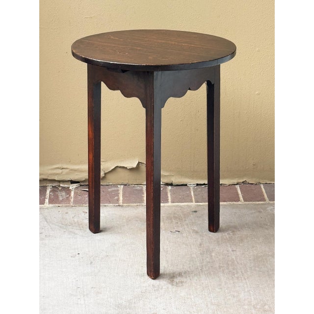 A handsome English cricket table of patinated oak from the late Georgian Era, c.1790, featuring the traditional round or...
