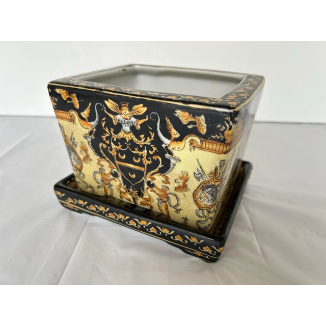 Elegant, decorative square planter or cachepot. Black and gold renaissance revival artistry featuring cherubini, coat of...