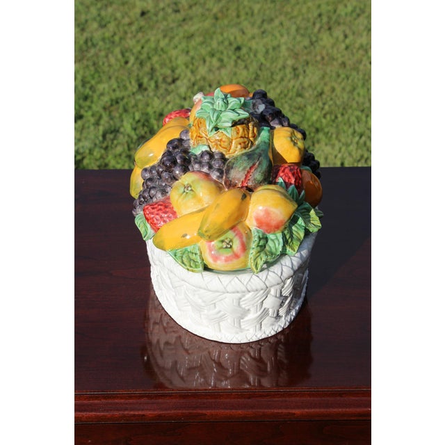 An abundance of fruit adorns this covered serving dish rendered in ceramic by Bordallo Pinheiro. It is marked on the...