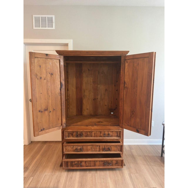 A beautifully detailed vintage wood cabinet featuring richly carved decorative door panels and a warm, aged wood finish....