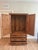 A beautifully detailed vintage wood cabinet featuring richly carved decorative door panels and a warm, aged wood finish....