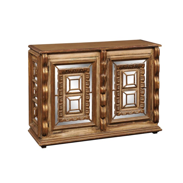 A Spanish console cabinet with beautifully carved and gilt geometric motifs and antiqued mirrored details, from the mid...