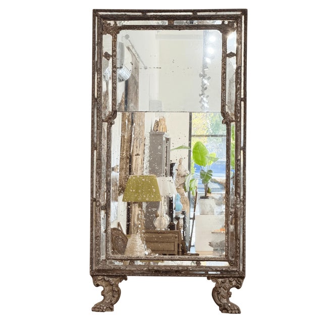 A Baroque silvered and giltwood mirror, Early 18th century; France, The carved wood frame with scroll and acanthus leaf...