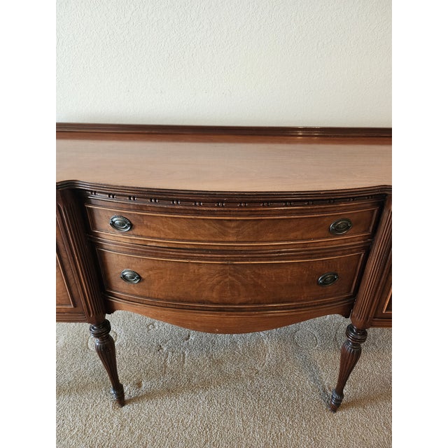 Sheraton-style mahogany wood buffet with banded inlay. Early 20th century. Two center drawers and two side cabinets. It's...
