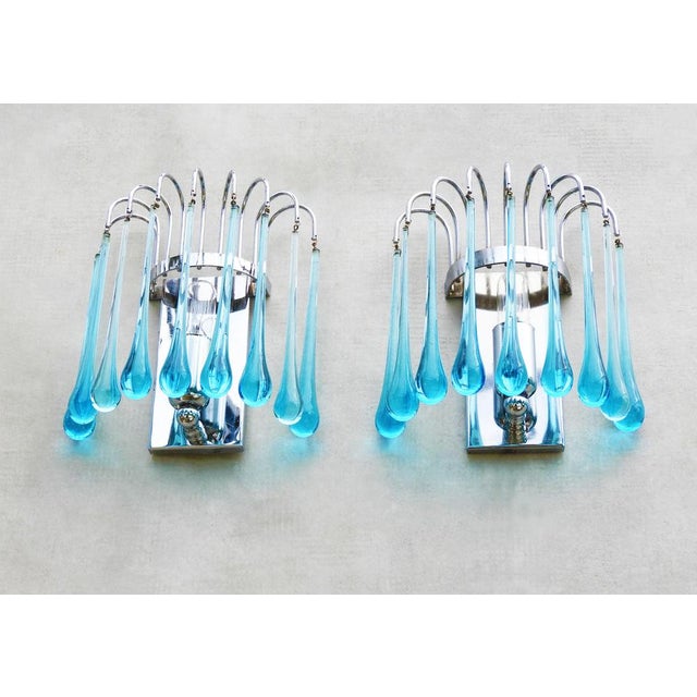 A pair of Paulo Venini-style waterfall wall light sconces. Striking Murano glass cascades each with nine blue ‘teardrop’...