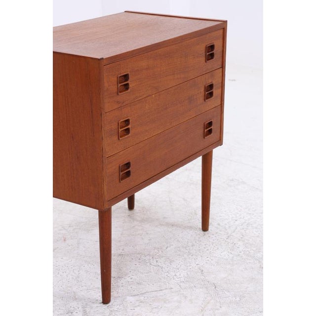 Vintage teak chest of drawers in Danish mid-century style with three spacious drawers and a side cabinet. The recessed...