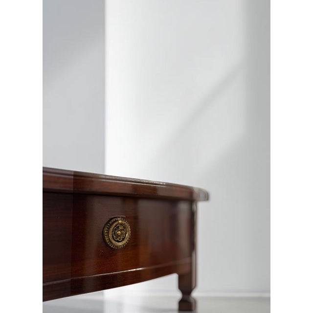 Vintage demi-lune console table executed in mahogany veneer. the piece features an elegant half-moon form with a curved...