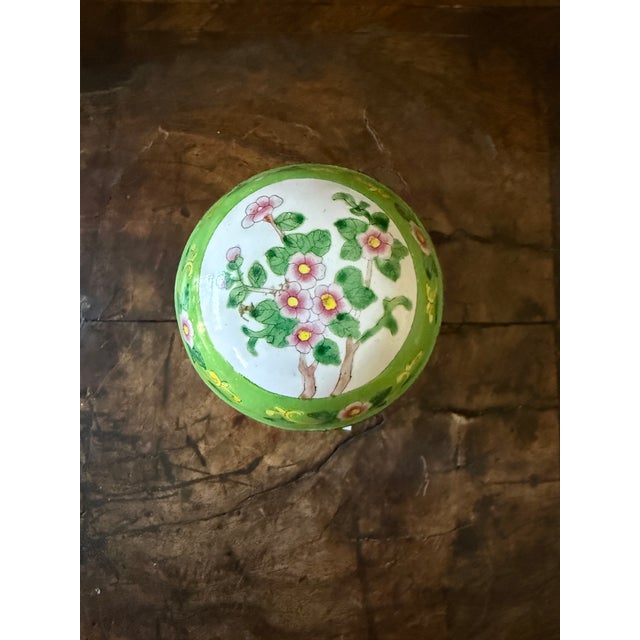 This charming Canton enamel trinket box features a vibrant green ground decorated with hand-painted pink blossoms, leafy...