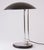 A midcentury german canopy lamp from the 1960s, featuring a sleek black and chrome design. The wide, domed metal shade is...