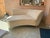 A sophisticated contemporary lounge sofa featuring an organic, curved silhouette. Upholstered in a soft cream-colored...