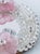 This is a small oval Venetian wall mirror from Fratelli Tosi of Murano, with a handworked clear glass frame and two pink...