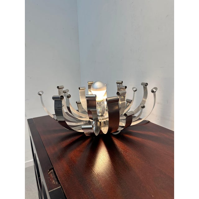 A striking pair of vintage chrome ribbon table lamps from the 1970s. sold separately . Designed with curved metal strips...