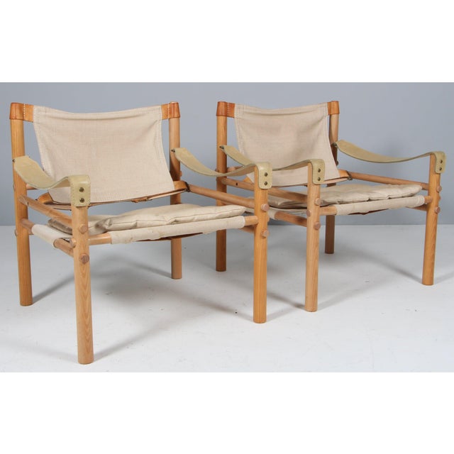Set of Arne Norell safari chairs with attachabel table. Rarely seen option. Original upholstered cushions with patinated...